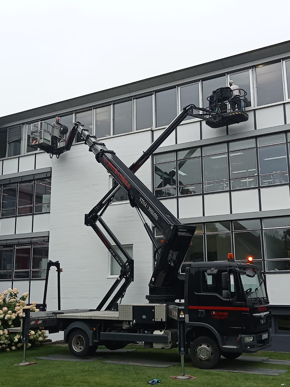 Reinigungsarbeit mit Steiger an einem Gebäude