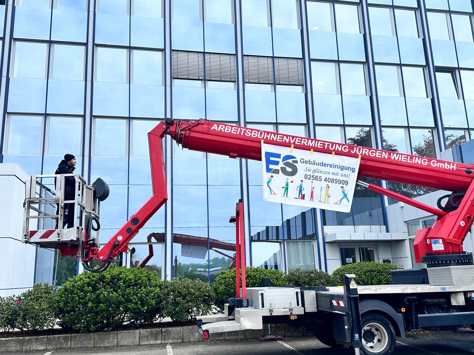 Außenreinigung mit Steiger an einem Glasgebäude